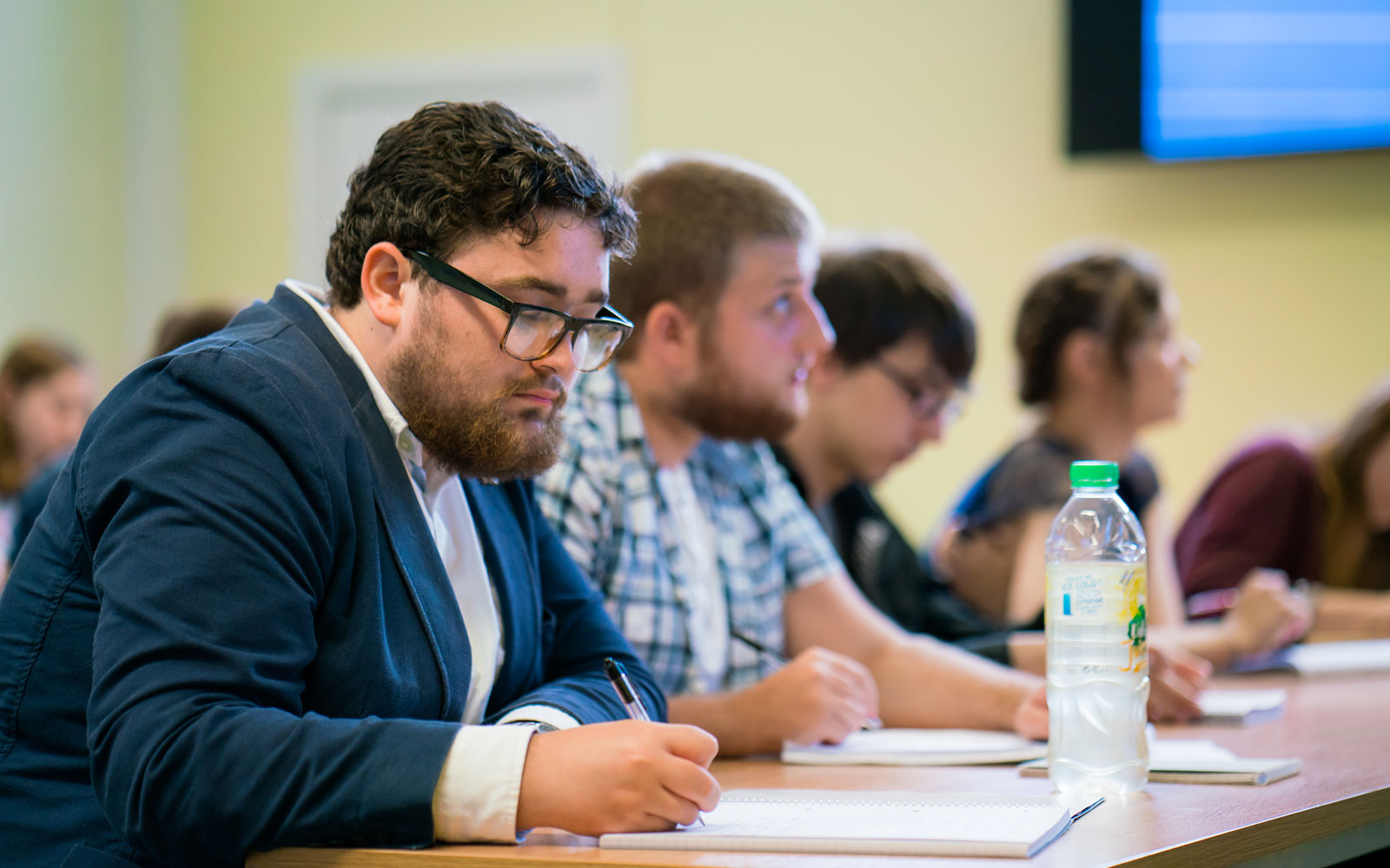 Students writing notes during a class.
