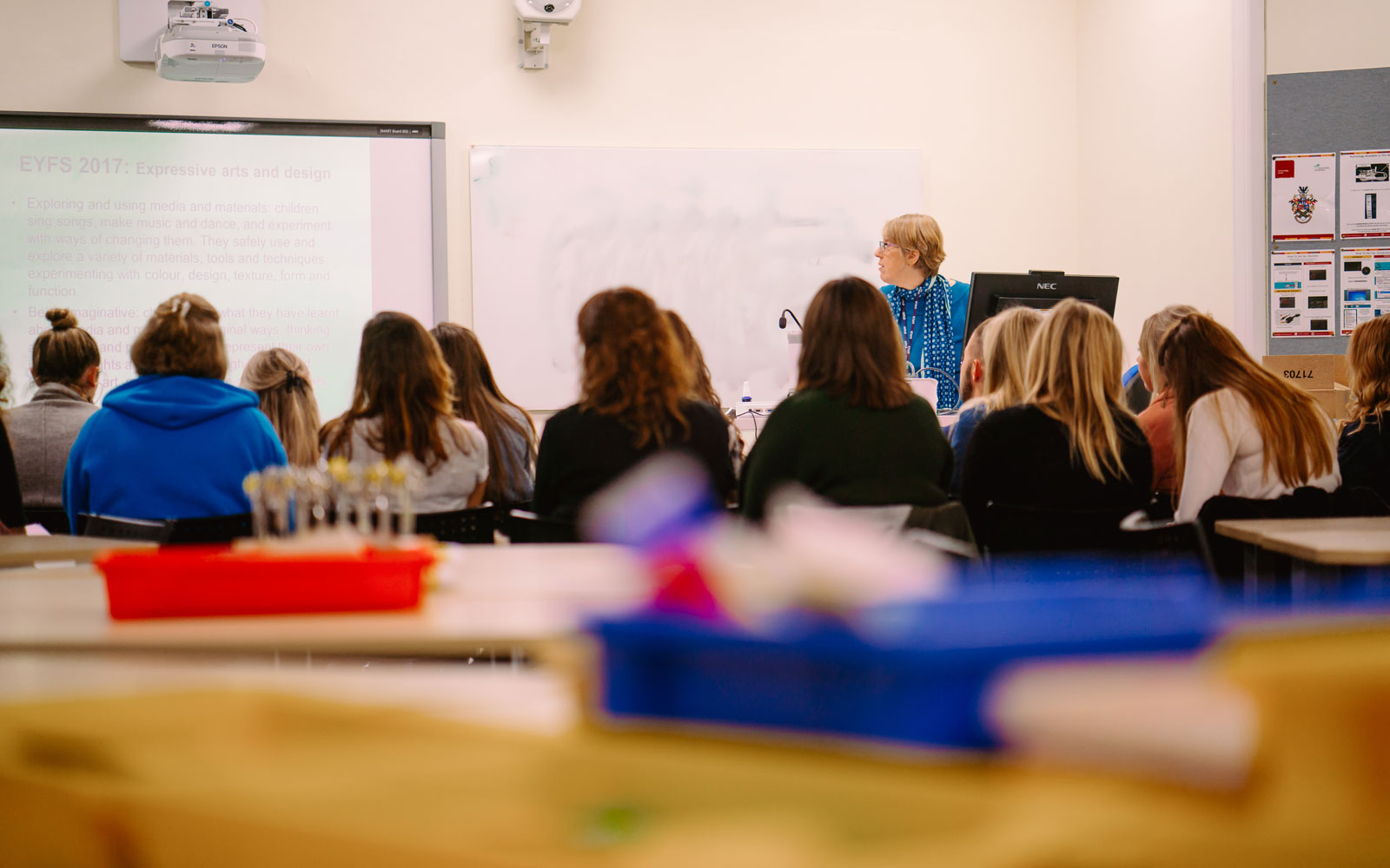 An image of students facing a lecturer in a classroom