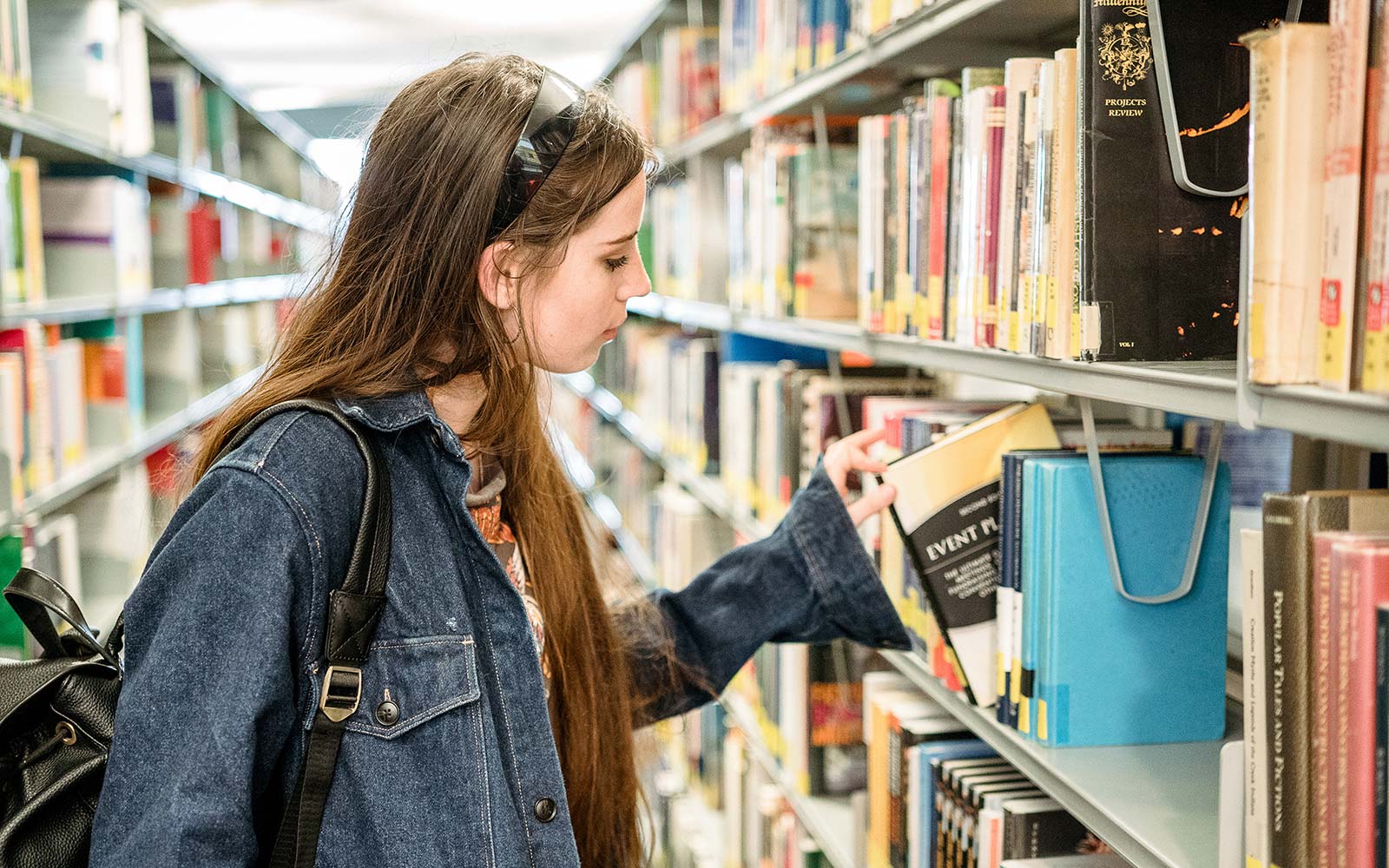 Events student looking at books in the library