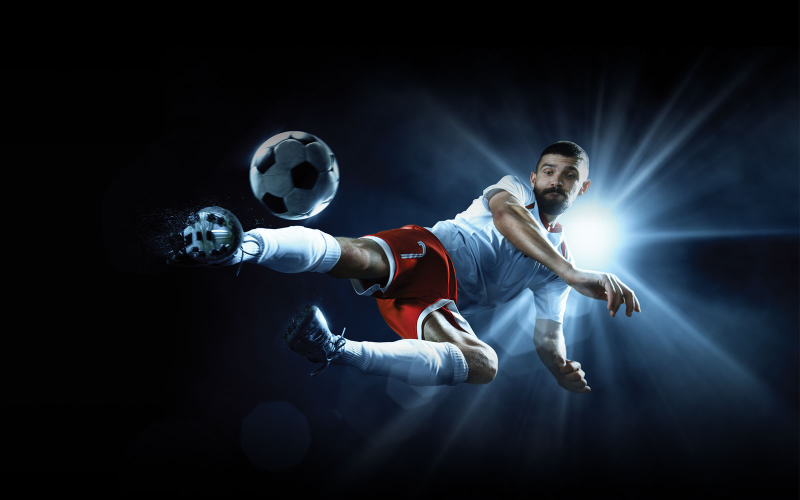 Professional footballer kicking a football