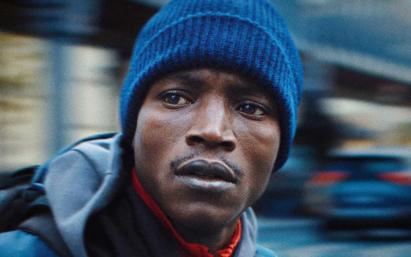 A male in a blue beanie hat with French text