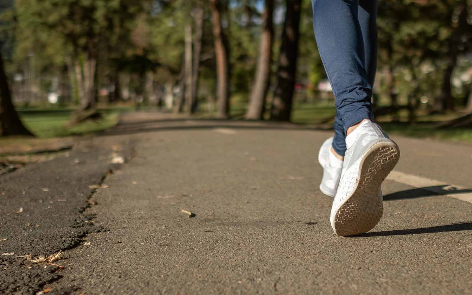 Close-up of a person walking down a path in a park. Photo by Daniel Reche on Pexels.