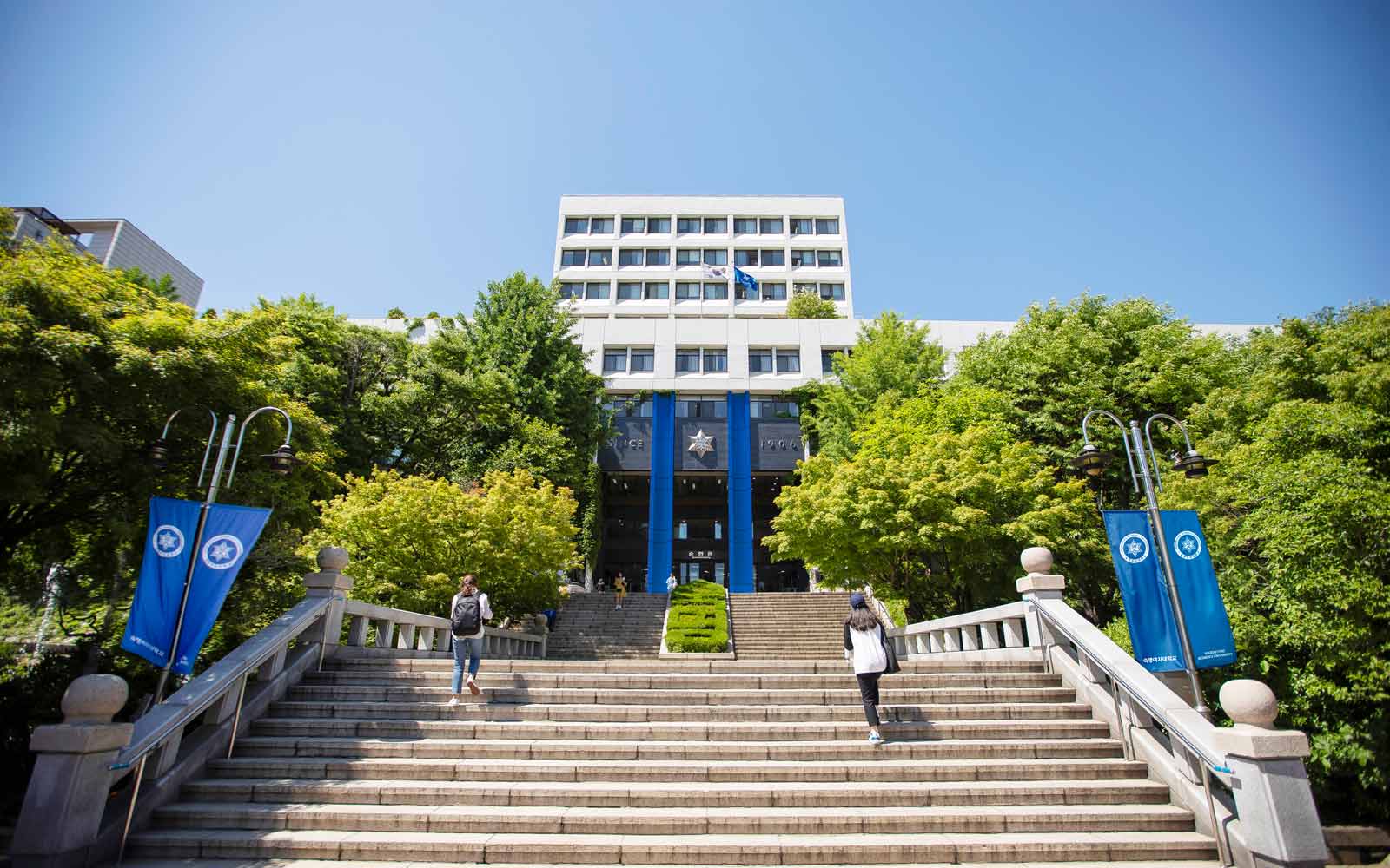 Wide stone staircase leading to modern building on Sookmyung Women's University campus.
