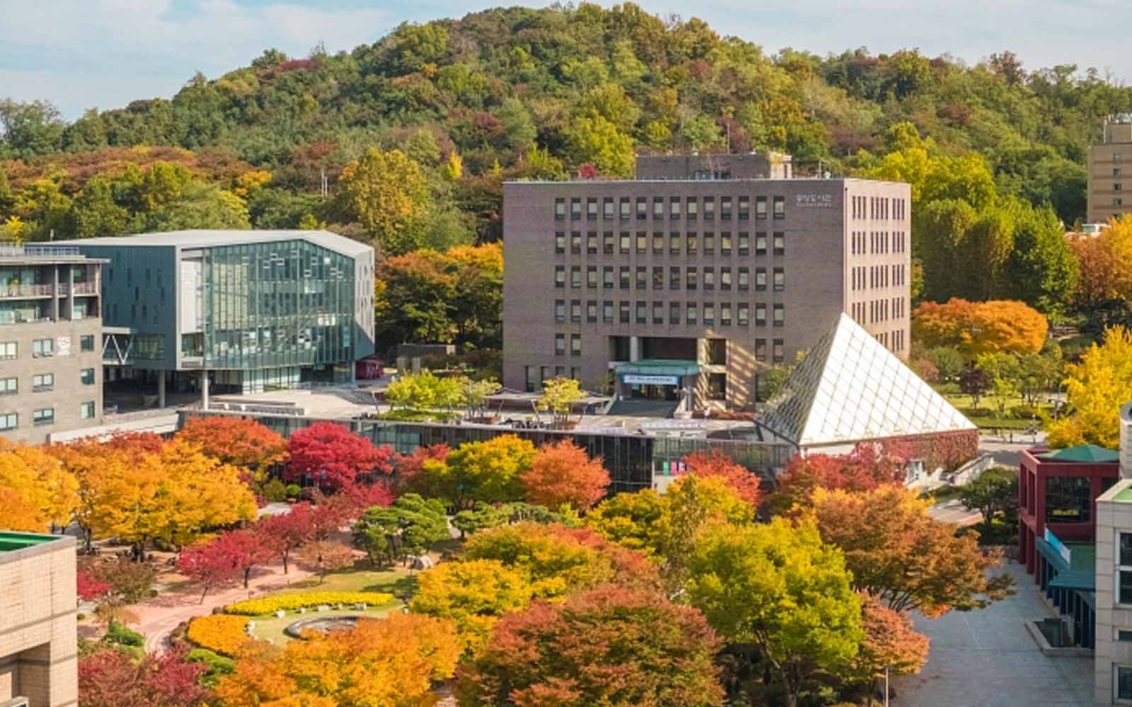 Modern buildings and glass pyramid surrounded by trees and landscaped plaza on Soongsil University campus.