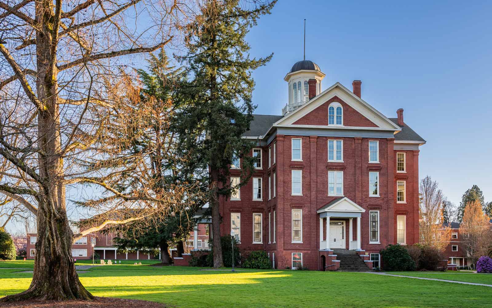 Historic building with trees and green space at Willamette University campus.