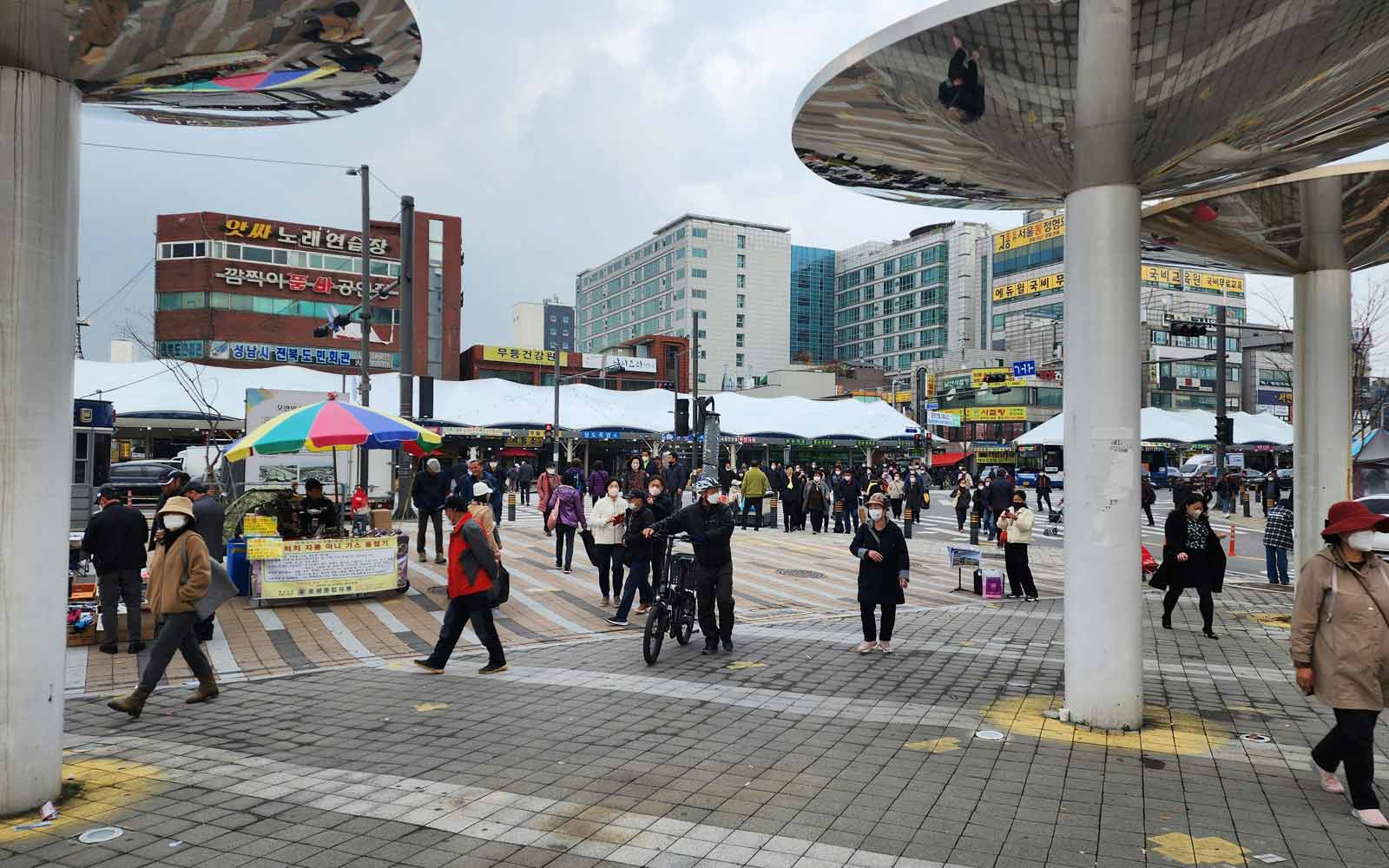 People walking around a traditional market, Seongnam-Si, South Korea. Photo by Don Moon on Unsplash.