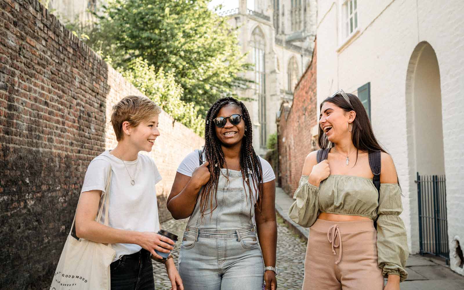 Students laughing and walking down street in York with Minster in background