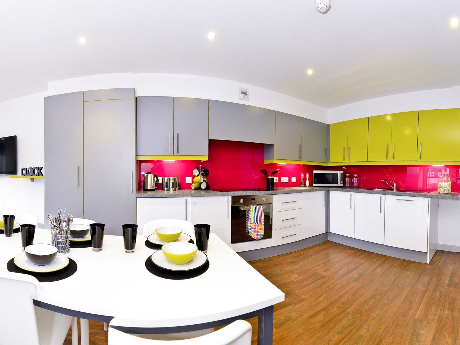 Kitchen at the boulevard, with range of wall cupboards, oven, microwave, fridge freezer and large table.