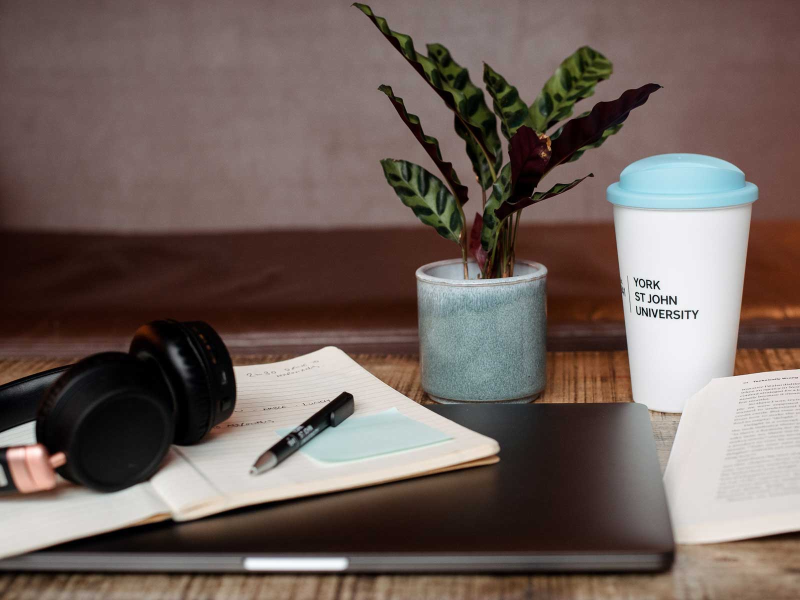 Laptop, headphones and notes on table