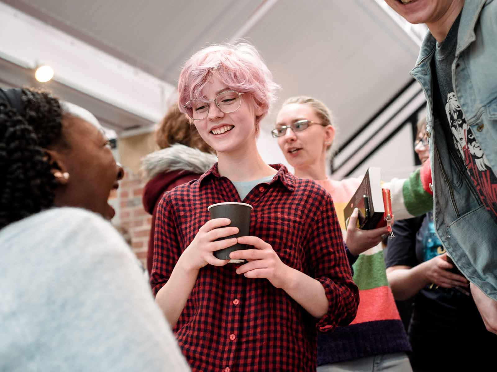 A student speaks to a guest at an event.