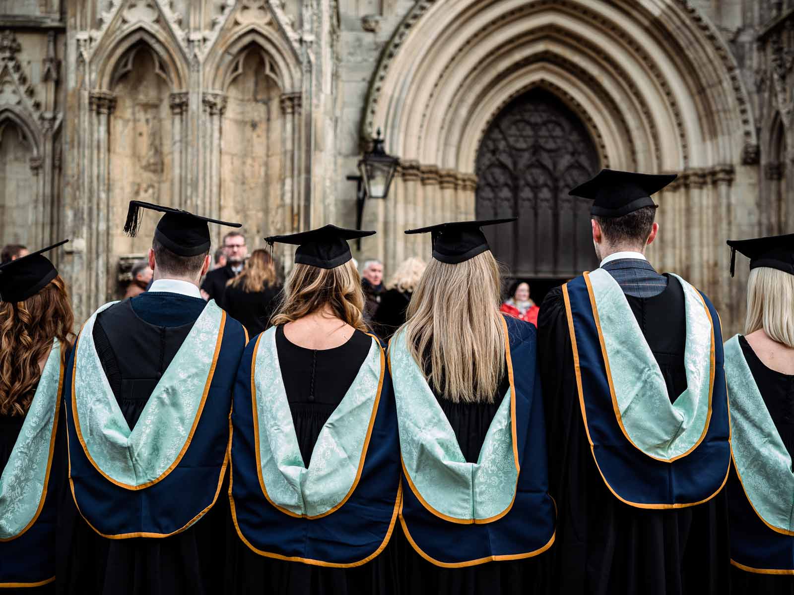 Students in a line in York St John graduation gowns.
