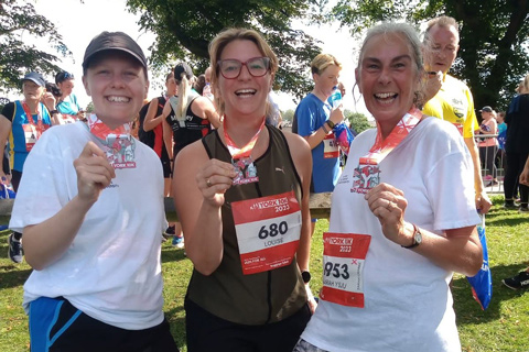 Three individuals celebrating at the 2023 York 10k run