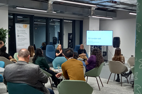 A group of individuals sitting together during a talk at the YSJ London Network event