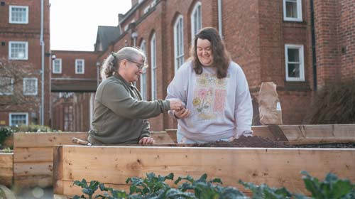 Two students gardening together