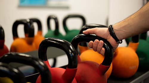 Hand reaching for kettlebell in YSJActive Gym