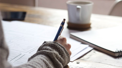 A student is writing in a notebook.