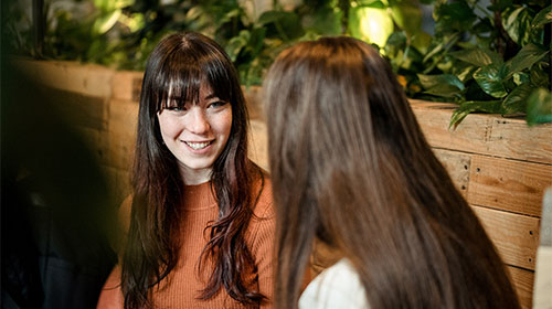 Two students sit and chat