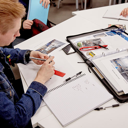 Interior Design student looking at photos of room and making notes
