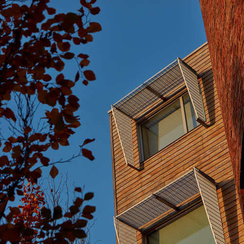 Close up of top floor of De Grey building exterior against blue sky