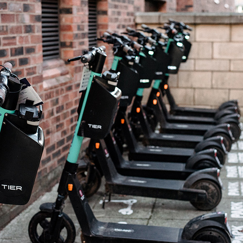 A row of electric scooters parked on the York St John campus
