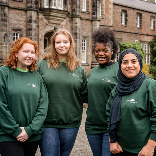 Group of Global Ambassadors smiling at camera outside on York Campus