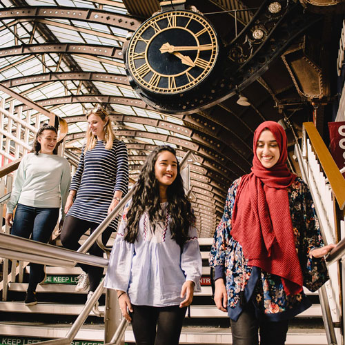 A group of students walking together at York railway station.