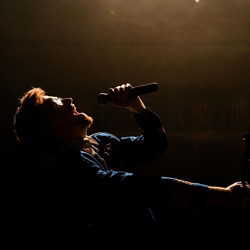 Musical Theatre student performing on stage singing into mic