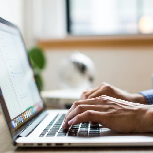 Close up of person typing on laptop keyboard