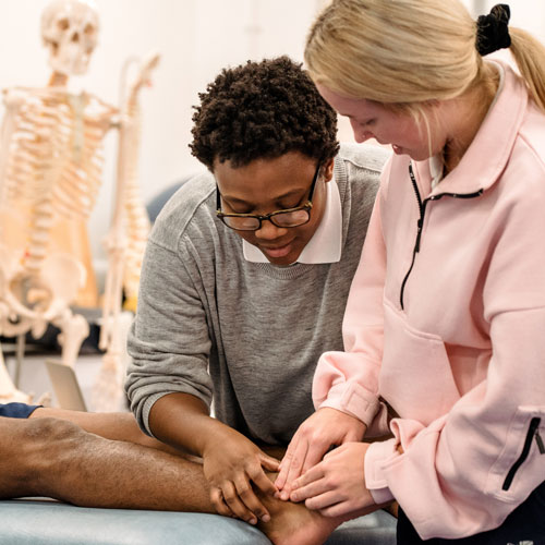 Student examining patient foot