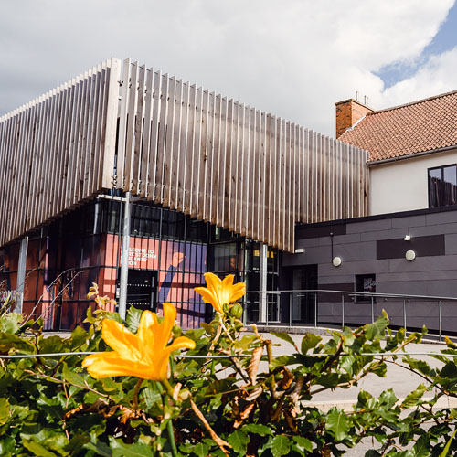 The York St John Students' Union building, with flowers in the foreground