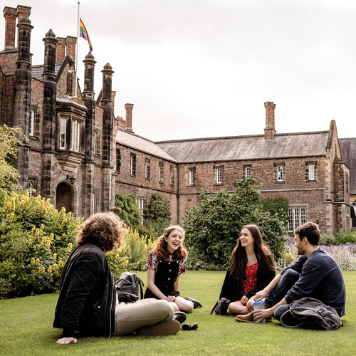 Four students sit together on campus.