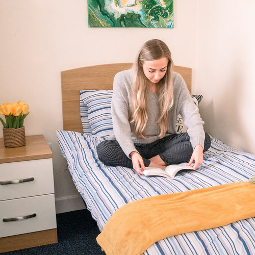 A student reading a book in Garden Street accommodation.