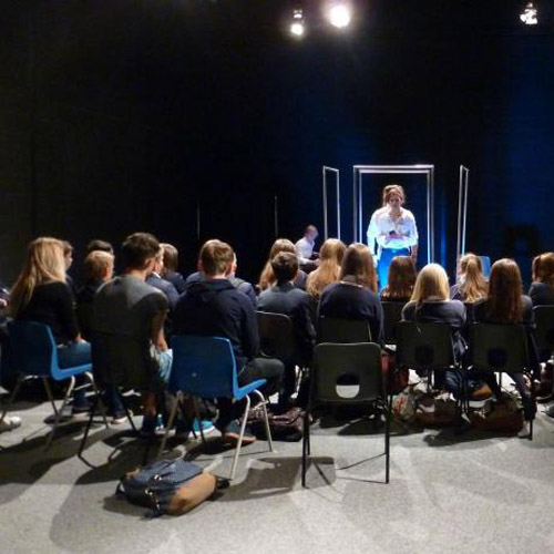 Audience on chairs facing performer in drama studio