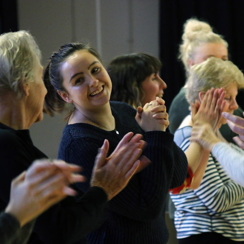 Adults stood in group clapping