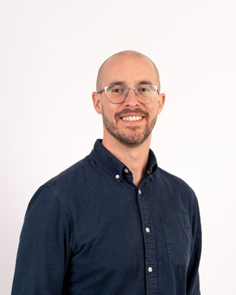 smiling man wearing glasses looking at the camera