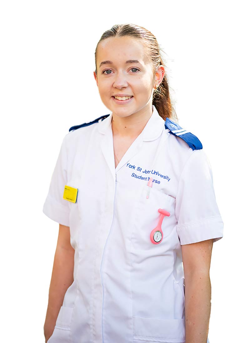 Female student nurse with brown hair, wearing her uniform and smiling to camera