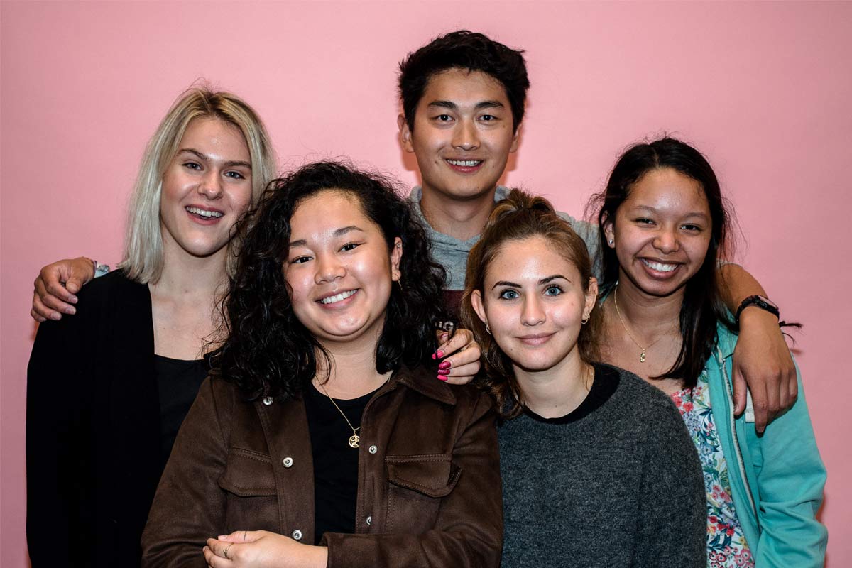 A group of students pose together in a photobooth.