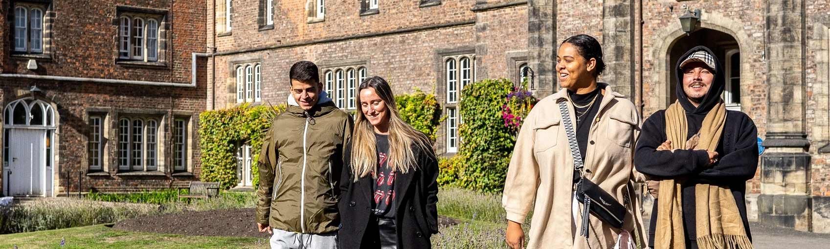 Four students walk together on campus.