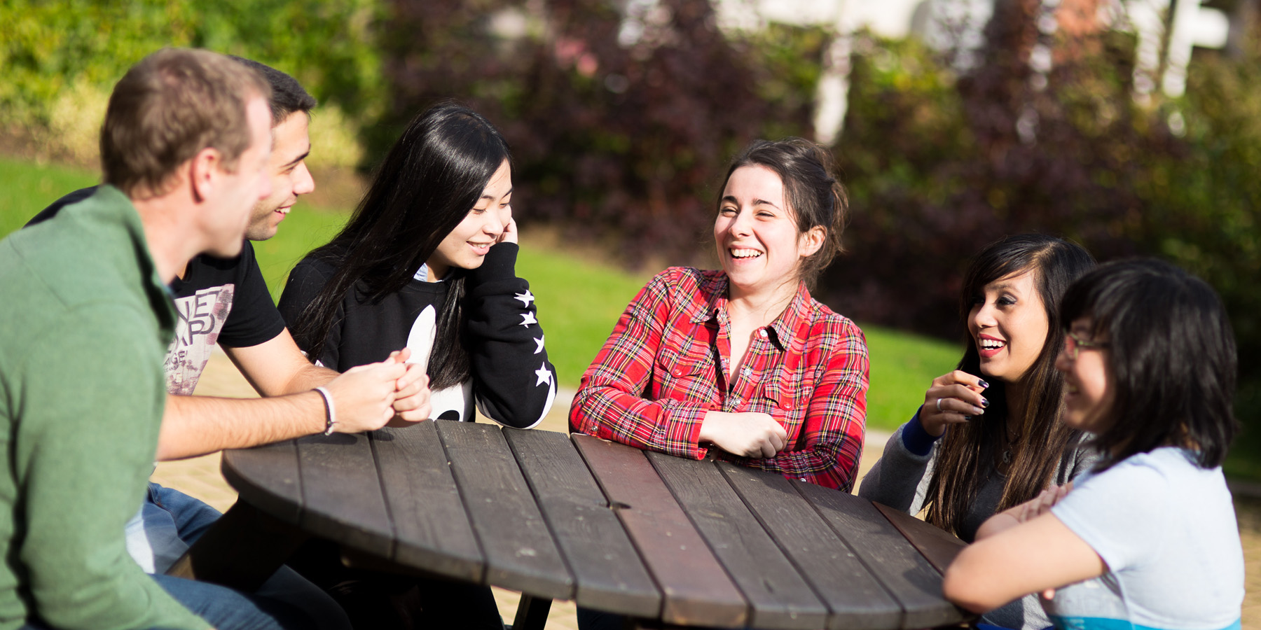 Students chatting outside at a table