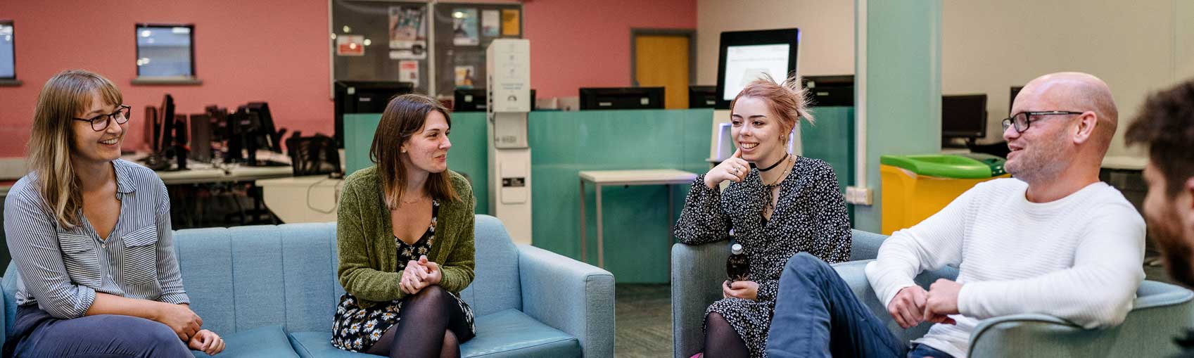 Staff in chairs around coffee table talking