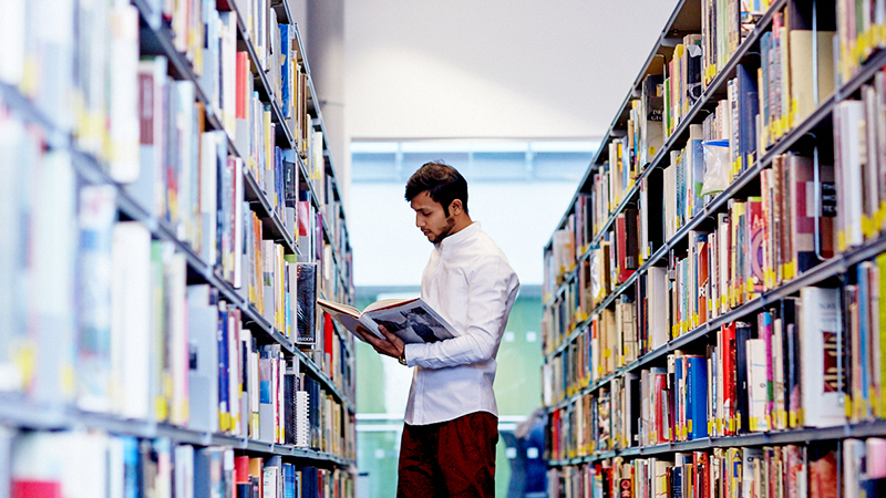Student in library choosing books