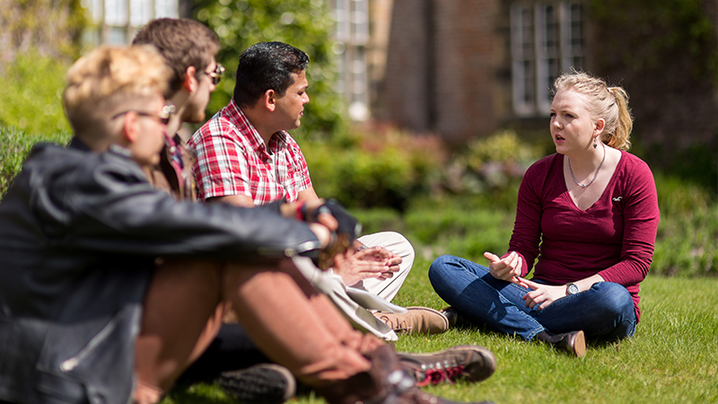 Students sitting on the grass talking
